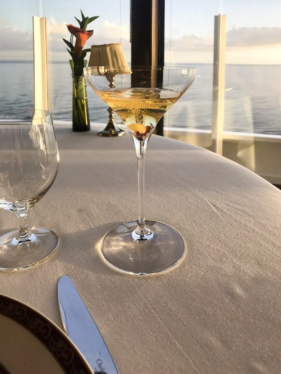 Cocktail glass on a table overlooking the sea at sunset