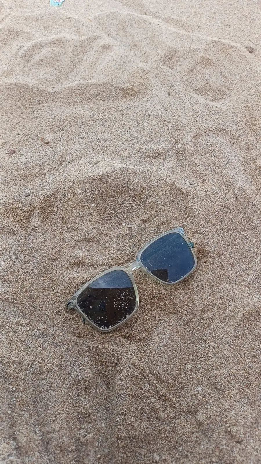 Sunglasses resting in the sand